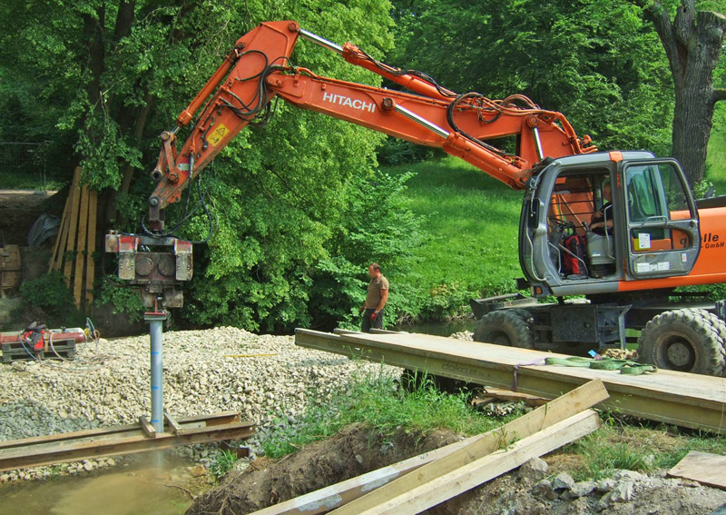 Ein Baustellenfahrzeug bohrt die Stahlrohre in die Flusssohle der Ilm